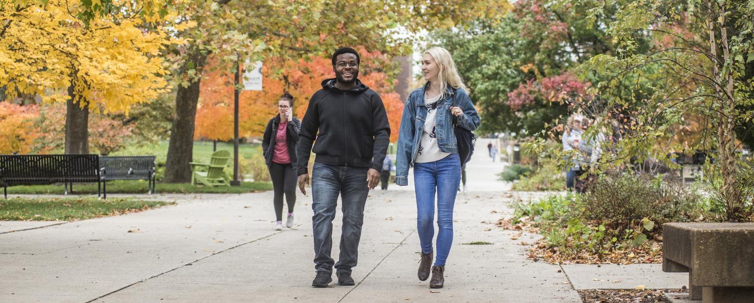 Students walking and discussing their class notes.